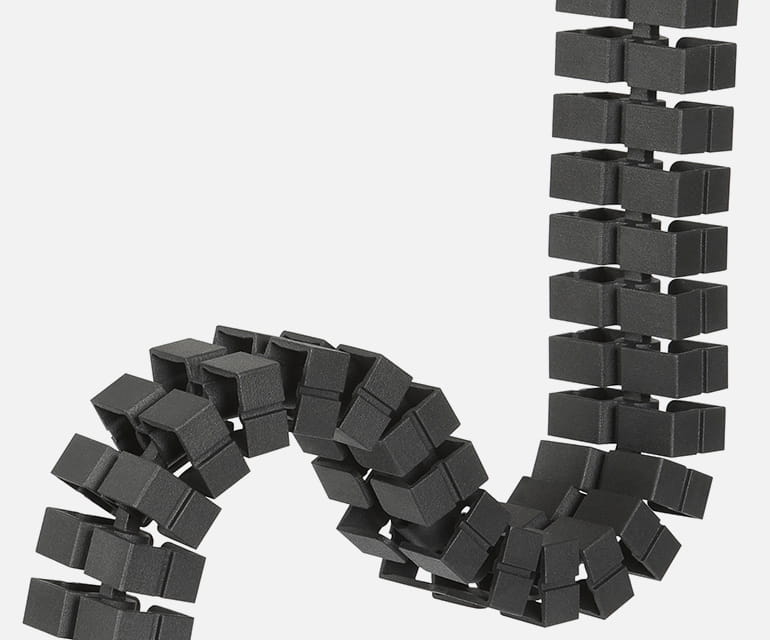 Spirale de câble noire flexible avec des segments carrés pour une gestion ordonnée des câbles, présentée sous une forme courbée.